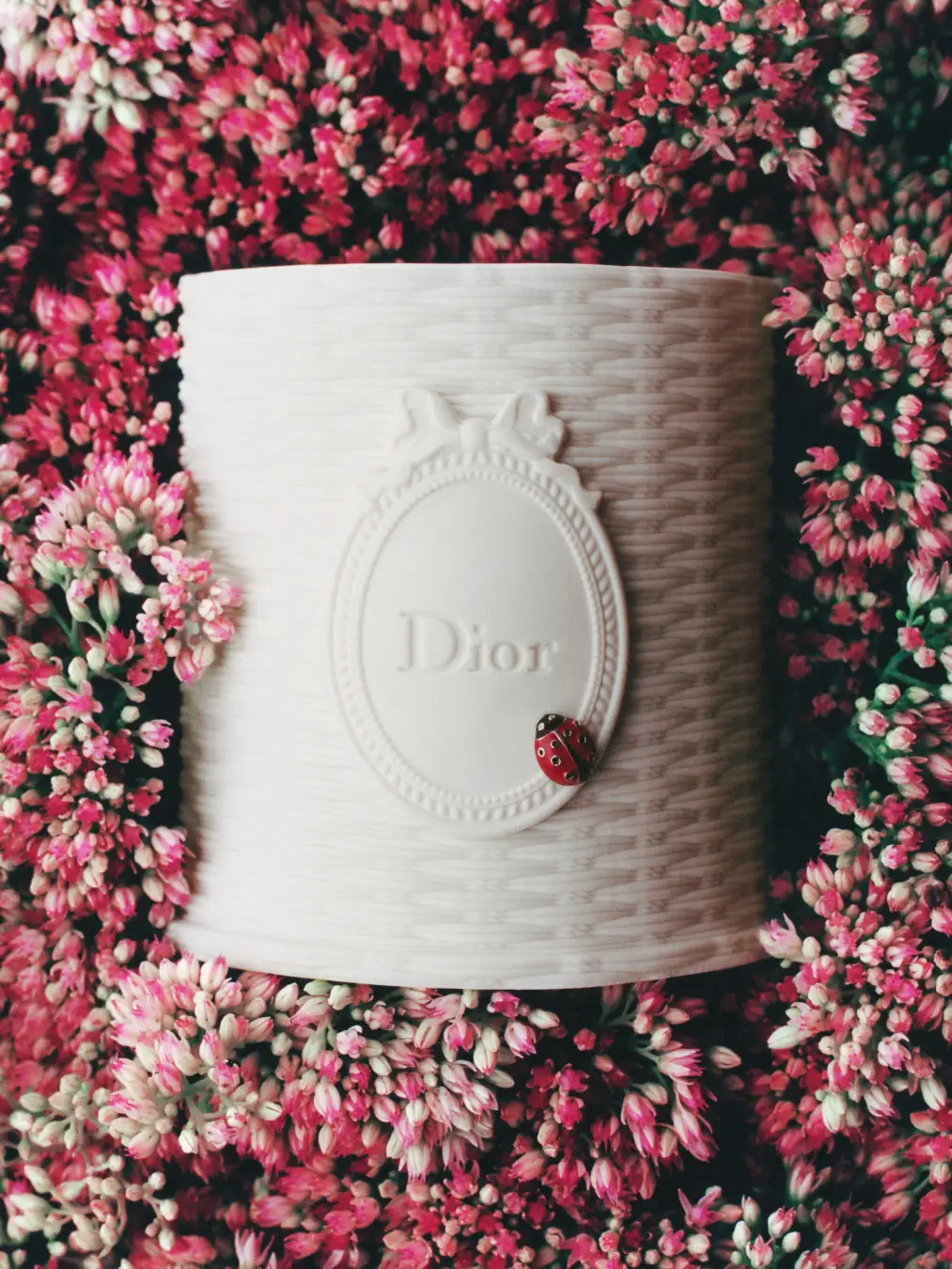 花を背景にしたホワイトのDiorキャンドル