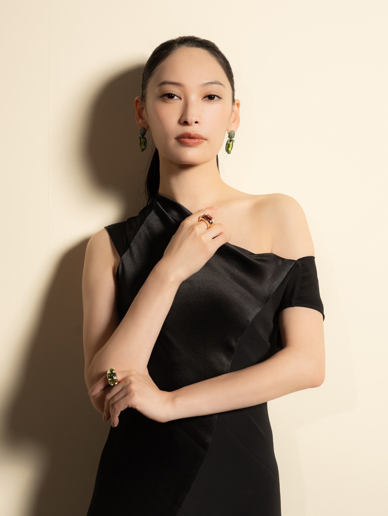 グリーンのイヤリングと黒いドレスを合わせた大政絢さん